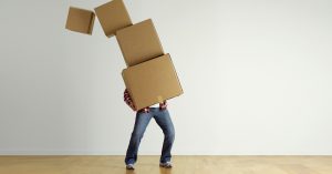 man carrying 4 boxes who needs storage space